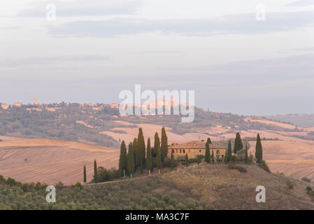 San Quirico d'Orcia, in der Provinz von Siena, Val d'Orcia, Toskana, Italien, Europa. Blick auf Podere Belvedere bei Sonnenuntergang mit Pienza auf dem Hintergrund Stockfoto