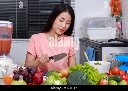 Deprimiert junge Frau Kochen mit Messer in der Küche Zimmer Stockfoto