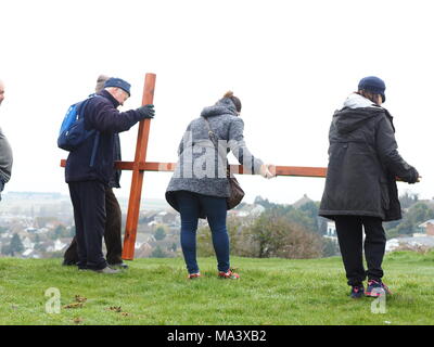 Münster am Meer, Kent, Großbritannien. 30. März, 2018. Karfreitag Zeremonie: Kirchen gemeinsam in Sheppey (CTiS) jährlichen Karfreitagsprozession des Zeugnisses. Drei Holzkreuze wurden von Sheerness, Eastchurch und auf halbem Weg zu einer Zeremonie im Regen an der Spitze der Glen in Münster am See, einer der höchsten Punkte der Insel Sheppey. Der einfache Dienst ist für alle Stückelungen von Kirchen gemeinsam organisiert in Sheppey (CTiS) und auf die grünen Hügel der Insel mit mehr als 35 Jahren statt. Credit: James Bell/Alamy leben Nachrichten Stockfoto