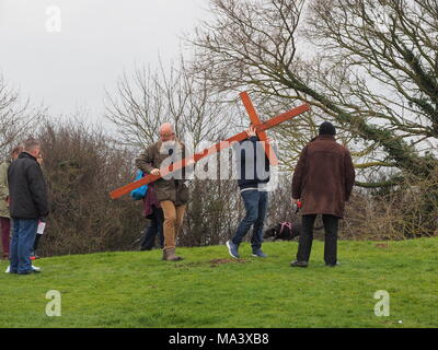 Münster am Meer, Kent, Großbritannien. 30. März, 2018. Karfreitag Zeremonie: Kirchen gemeinsam in Sheppey (CTiS) jährlichen Karfreitagsprozession des Zeugnisses. Drei Holzkreuze wurden von Sheerness, Eastchurch und auf halbem Weg zu einer Zeremonie im Regen an der Spitze der Glen in Münster am See, einer der höchsten Punkte der Insel Sheppey. Der einfache Dienst ist für alle Stückelungen von Kirchen gemeinsam organisiert in Sheppey (CTiS) und auf die grünen Hügel der Insel mit mehr als 35 Jahren statt. Credit: James Bell/Alamy leben Nachrichten Stockfoto