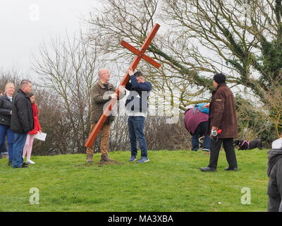 Münster am Meer, Kent, Großbritannien. 30. März, 2018. Karfreitag Zeremonie: Kirchen gemeinsam in Sheppey (CTiS) jährlichen Karfreitagsprozession des Zeugnisses. Drei Holzkreuze wurden von Sheerness, Eastchurch und auf halbem Weg zu einer Zeremonie im Regen an der Spitze der Glen in Münster am See, einer der höchsten Punkte der Insel Sheppey. Der einfache Dienst ist für alle Stückelungen von Kirchen gemeinsam organisiert in Sheppey (CTiS) und auf die grünen Hügel der Insel mit mehr als 35 Jahren statt. Credit: James Bell/Alamy leben Nachrichten Stockfoto