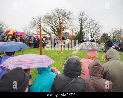 Münster am Meer, Kent, Großbritannien. 30. März, 2018. Karfreitag Zeremonie: Kirchen gemeinsam in Sheppey (CTiS) jährlichen Karfreitagsprozession des Zeugnisses. Drei Holzkreuze wurden von Sheerness, Eastchurch und auf halbem Weg zu einer Zeremonie im Regen an der Spitze der Glen in Münster am See, einer der höchsten Punkte der Insel Sheppey. Der einfache Dienst ist für alle Stückelungen von Kirchen gemeinsam organisiert in Sheppey (CTiS) und auf die grünen Hügel der Insel mit mehr als 35 Jahren statt. Credit: James Bell/Alamy leben Nachrichten Stockfoto