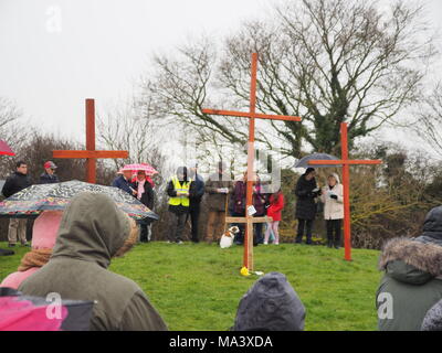 Münster am Meer, Kent, Großbritannien. 30. März, 2018. Karfreitag Zeremonie: Kirchen gemeinsam in Sheppey (CTiS) jährlichen Karfreitagsprozession des Zeugnisses. Drei Holzkreuze wurden von Sheerness, Eastchurch und auf halbem Weg zu einer Zeremonie im Regen an der Spitze der Glen in Münster am See, einer der höchsten Punkte der Insel Sheppey. Der einfache Dienst ist für alle Stückelungen von Kirchen gemeinsam organisiert in Sheppey (CTiS) und auf die grünen Hügel der Insel mit mehr als 35 Jahren statt. Credit: James Bell/Alamy leben Nachrichten Stockfoto