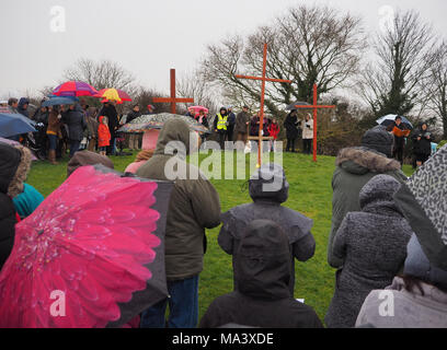Münster am Meer, Kent, Großbritannien. 30. März, 2018. Karfreitag Zeremonie: Kirchen gemeinsam in Sheppey (CTiS) jährlichen Karfreitagsprozession des Zeugnisses. Drei Holzkreuze wurden von Sheerness, Eastchurch und auf halbem Weg zu einer Zeremonie im Regen an der Spitze der Glen in Münster am See, einer der höchsten Punkte der Insel Sheppey. Der einfache Dienst ist für alle Stückelungen von Kirchen gemeinsam organisiert in Sheppey (CTiS) und auf die grünen Hügel der Insel mit mehr als 35 Jahren statt. Credit: James Bell/Alamy leben Nachrichten Stockfoto