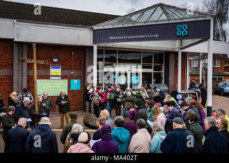 LEOMINSTER, HEREFORDSHIRE, UK - 30. März: Mitglieder der christlichen Gemeinschaft außerhalb der Co-op-Supermarkt in Leominster sammeln Teil in einer Karfreitagsprozession als Teil der Heiligen Woche und am 30. März 2018. Während der Wanderung von Zeugnis, das sie die symbolische Kreuz von der Baptist Church auf Etnam Street durch die mittelalterlichen Markt Marktplatz zum Kloster Kirche der Church Street, wo das Kreuz errichtet werden. Viele Städte und Dörfer schon halten Sie Spaziergänge oder Märsche des Zeugnisses als Zeichen ihrer gemeinsamen Glauben an den Tod und die Auferstehung von Jesus Christus. Die christlichen Feiertag erinnert an den cru Stockfoto