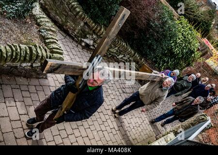 LEOMINSTER, HEREFORDSHIRE, UK - 30. März: Mitglieder von Leominster St Ethelbert der Kirche tragen das Kreuz durch die Grange das Priorat Kirche als christliche Gemeinschaft in Leominster sammeln Teil in einer Karfreitagsprozession als Teil der Heiligen Woche und am 30. März 2018. Während der Wanderung von Zeugnis, das sie die symbolische Kreuz von der Baptist Church auf Etnam Street durch die mittelalterlichen Markt Marktplatz zum Kloster Kirche der Church Street, wo das Kreuz errichtet werden. Viele Städte und Dörfer schon halten Sie Spaziergänge oder Märsche des Zeugnisses als Zeichen ihrer gemeinsamen Glauben an den Tod und die resurr Stockfoto