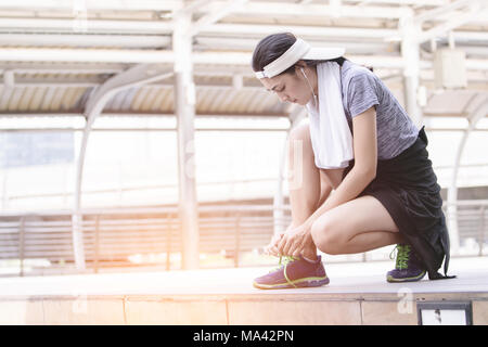 Athlet Frau binden Laufschuhe bereit für Joggen Stockfoto
