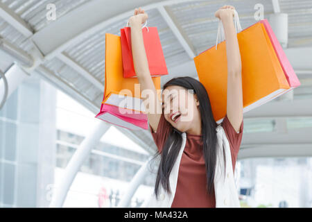Schöne Frauen Shopping genießen, lächelnde Frauen angehoben bunten Einkaufstaschen Stockfoto