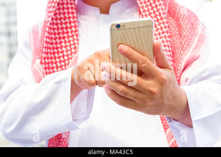 Saudi-arabische Emirate hand Sms in ein smart phone Stockfoto