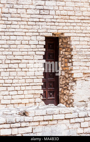 Festungsmauer Eingang mit hölzernen Tür. Römisches Mauerwerk in Pula. Stockfoto