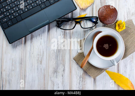 Herbst noch leben. Tea Party Herbst Tag Tasse Kaffee, Kuchen, Nüsse, Blätter, Blumen, Brille und Laptop. Kopieren Sie Platz. Stockfoto