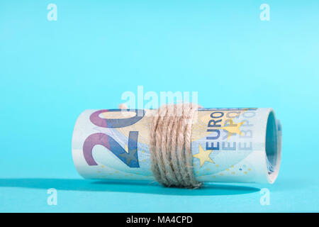 Zwanzig Euro rollte über einen blauen Hintergrund. Die Kopie Raum Stockfoto