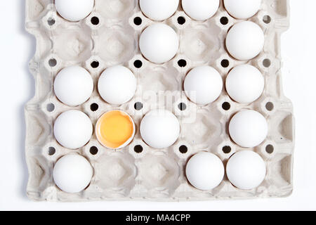 Die gebrochene Eier mit der anderen weißen Eier im Karton aus dem Store. Es sieht aus wie ein Schachbrett. Stockfoto