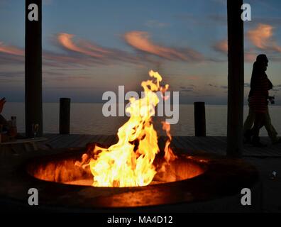 Flackernden Flammen im Outdoor Feuerstelle entlang Pier mit Paar durch, in Florida Keys, USA Stockfoto