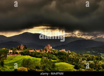 Das Dorf Ciglié mit seiner mittelalterlichen Burg, in den Langhe, Piemont, Italty. Im Hintergrund der Seealpen und den Berg Mindino. Stockfoto