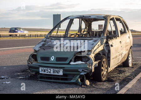 Beschädigte aufgegeben ausgebrannt Auto an der Seite der Straße bleibt, Großbritannien Stockfoto