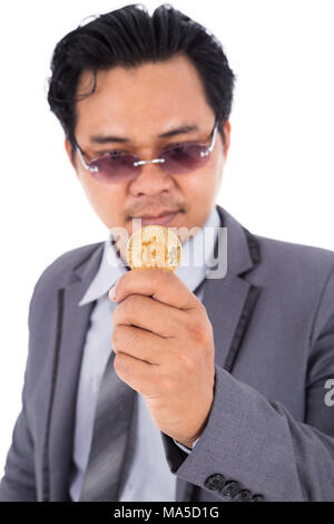Mann mit goldenen Bitcoin in der Hand auf einem weißen Hintergrund isoliert Stockfoto