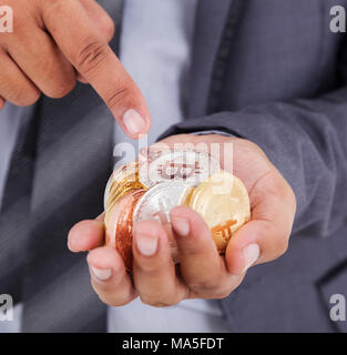 Bitcoin in der Hand von Mann mit Anzug Stockfoto