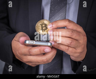Nahaufnahme, Geschäftsmann mit bitcoin und über ein Mobiltelefon Stockfoto