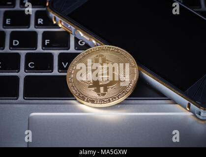 Bitcoin mit Mobile auf einem Laptop Tastatur computer Hintergrund Stockfoto