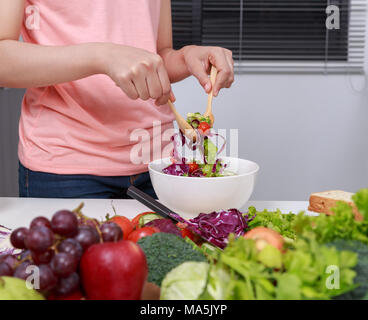 Nahaufnahme junge Frau mischen Salat beim Kochen in der Küche Stockfoto