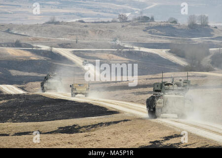 Us-Soldaten mit 5 Squadron, 4th Cavalry Regiment, 2. gepanzerte Brigade Combat Team, 1.Infanterie Division bewegen ihre Bradley Fighting Fahrzeuge für eine kombinierte Waffen live fire Übung mit Task Force Viper 1 Bataillon, 3 Aviation Regiment, 12 Combat Aviation Brigade an der 7th Army Training Befehl Grafenwöhr Training Area, Deutschland, 26. März 2018. (U.S. Armee Foto von Gertrud Zach) Stockfoto