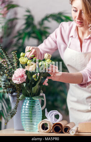 Portrait von Floristen Frau mit Vase und Blumenstrauß im Zimmer Stockfoto