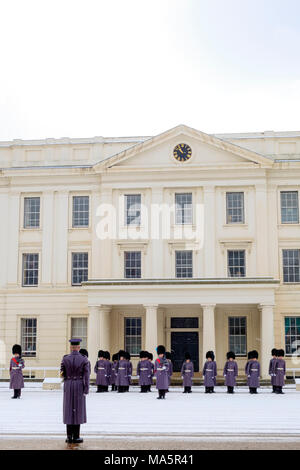 Irish Guards aus dem Queens Guard Regimenter Vorbereitung für den Wachwechsel Zeremonie mit einer Inspektion im Schnee am Wellington Barracks Stockfoto