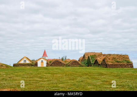 Dorf in Island mit Kirche und traditionellen Torfhäuser Stockfoto