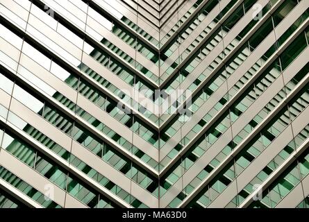 Abstrakte Sicht der modernen Glasfassade eines Hochhauses, die von einem kräftigen, Geometrie, Symmetrie und sattem grün Töne Stockfoto