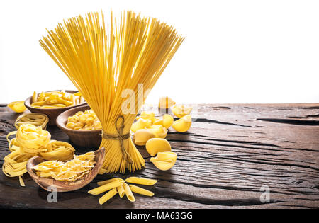 Verschiedene pasta Typen auf Holztisch. Weißer Hintergrund. Stockfoto