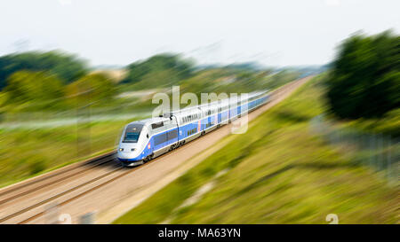 Ein Doppeldecker TGV Duplex Hochgeschwindigkeitszug in Atlantischer Lackierung von der französischen Firma SNCF, der mit voller Geschwindigkeit auf dem Land fährt (mit Bewegungsunschärfe). Stockfoto