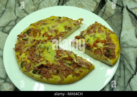 Blumenkohl in Scheiben geschnittene hausgemachte Pizza Kruste mit Mozarella und frischem Basilikum in Dripping pan auf Schwarz konkreten Hintergrund Stockfoto
