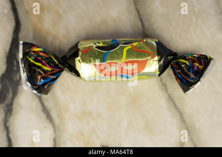 Fünf Bonbons in farbigen Folien auf weiße Maske Hintergrund gewickelt Stockfoto