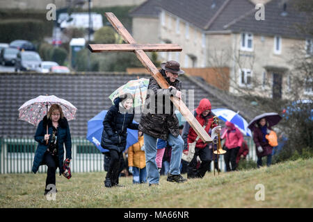 Ein hölzernes Kreuz ist ausgeführt, Roundhill in Badewanne, Wiltshire, wo mehrere christliche Kirchengemeinden an den Fuß des Zeugnisses die Reise zu imitieren, nahm Jesus sein Kreuz trug durch die Straßen von Jerusalem am Karfreitag. Stockfoto