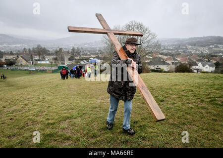 Ein hölzernes Kreuz ist ausgeführt, Roundhill in Badewanne, Wiltshire, wo mehrere christliche Kirchengemeinden an den Fuß des Zeugnisses die Reise zu imitieren, nahm Jesus sein Kreuz trug durch die Straßen von Jerusalem am Karfreitag. Stockfoto