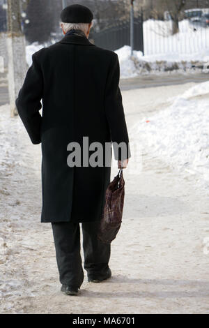Junge stilvollen Mann in warm grey Fell und Leder Handschuhe auf der Straße. Street Style Stockfoto