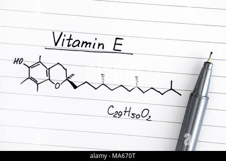 Die chemische Formel von Vitamin E auf liniertem Papier mit Stift. Close-up. Stockfoto