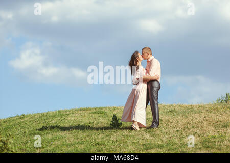 Liebenden Mann und Frau stand auf einem Hügel und küssen sich. Stockfoto