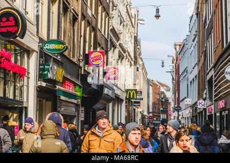 Amsterdam, Niederlande - März 2018: Menschen zu Fuß auf belebten Straße im Stadtzentrum von Amsterdam, an einem sonnigen Tag Stockfoto