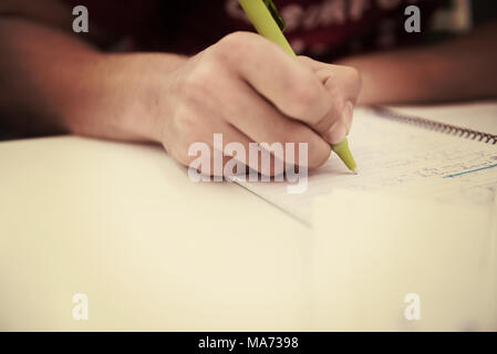 Nahaufnahme eines Studenten Hand unterstreichen ein Dokument auf einem Schreibtisch in der Schule Klassenzimmer Stockfoto