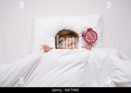 Junge schöne Frau Angst, Wecker, um sich am Morgen Stockfoto
