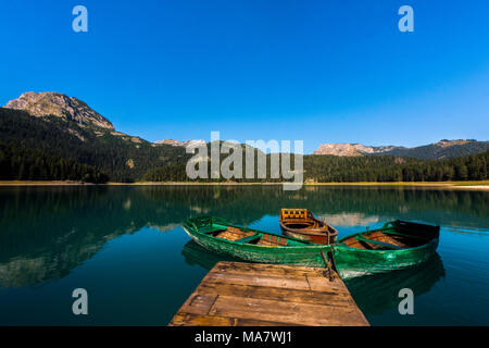 Mountain Lake Schwarzer See' Crno jezero" mit Booten aus Holz und Reflexionen im Nationalpark Durmitor Stockfoto