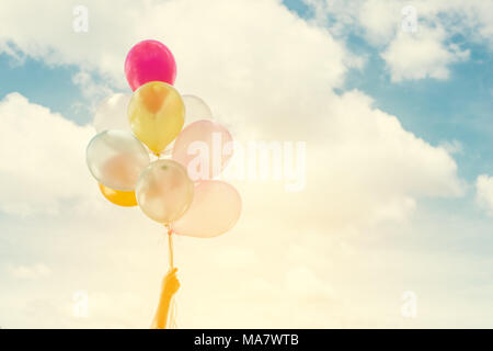 Frau lifestyle Konzept: Frau Hände ein Bündel von farbigen Luftballons mit blauer Himmel Sommer Holding das Leben genießen. Stockfoto