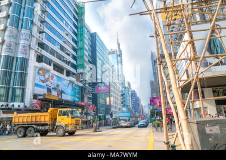 KOWLOON, HONG KONG - 18. SEPTEMBER 2017; typisch asiatischen Downtown city street scene mit modernen Gebäuden auf einer Seite Bambus Gerüst auf der anderen Straßenseite Stockfoto