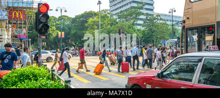 KOWLOON, HONG KONG - 18. SEPTEMBER 2017; typisch asiatischen Downtown city street scene Reisende mit Koffern Kreuzung auf rotes Licht Stockfoto