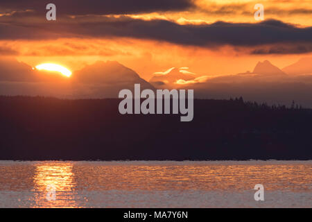Sunrise, Sonne, über den Bergen. Sonnenuntergang in den Bergen mit Panoramablick. Farbenfroh und malerischen Sonnenaufgang über die Cascade Mountains. Aus Port Townsend. Stockfoto