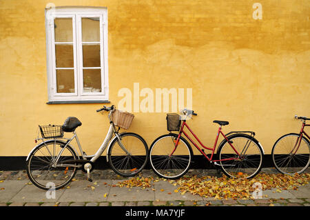 Fahrräder gegen gelbe Haus in Brumleby, Kopenhagen, Dänemark Stockfoto