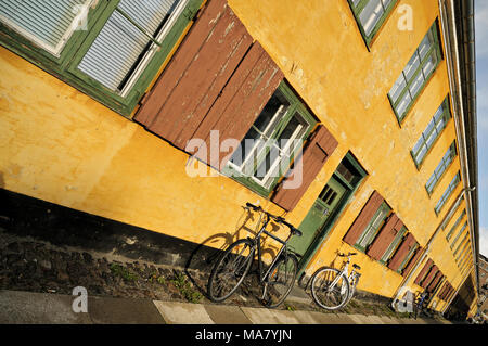 Fahrräder gegen gelbe Haus in Nyboder, Kopenhagen, Dänemark Stockfoto