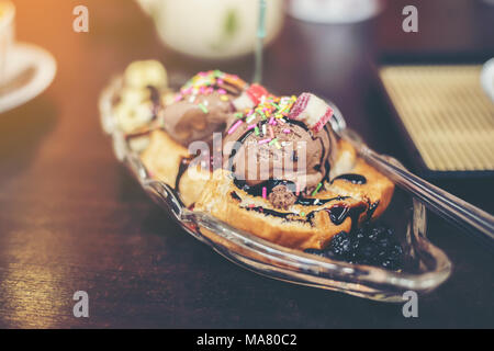 Banana Split Sonntag Eis in einer Schüssel mit Erdbeere und Zitrone choc Vanilleeis Schaufeln Stockfoto